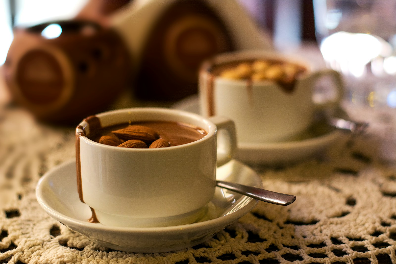 two cups of hot chocolate with nuts in them